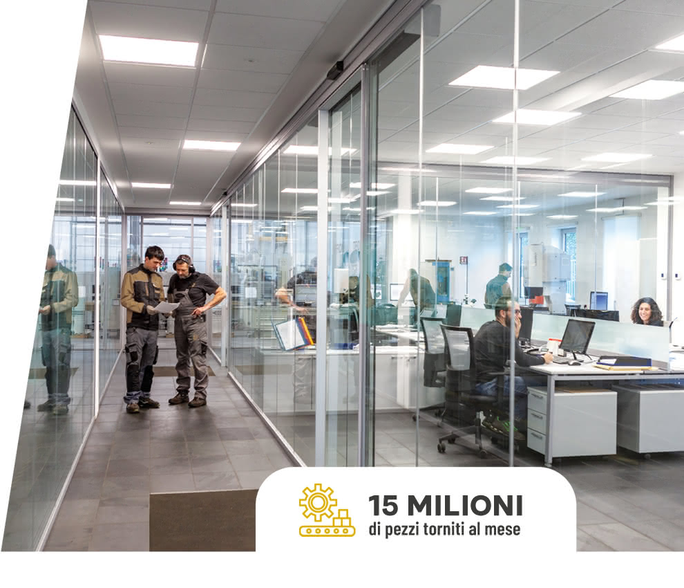 Uffici tecnici e amministrativi Eredi Baitelli, con vetrate a tutta altezza e personale al lavoro in ambiente luminoso e trasparente.