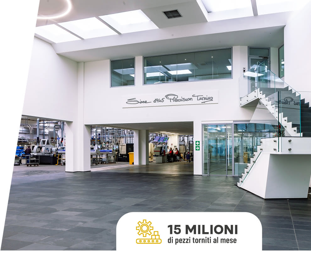 Ingresso al reparto produttivo Eredi Baitelli visto dall’atrio aziendale, con scala in vetro e scritta «Since 1945 Precision Turning».