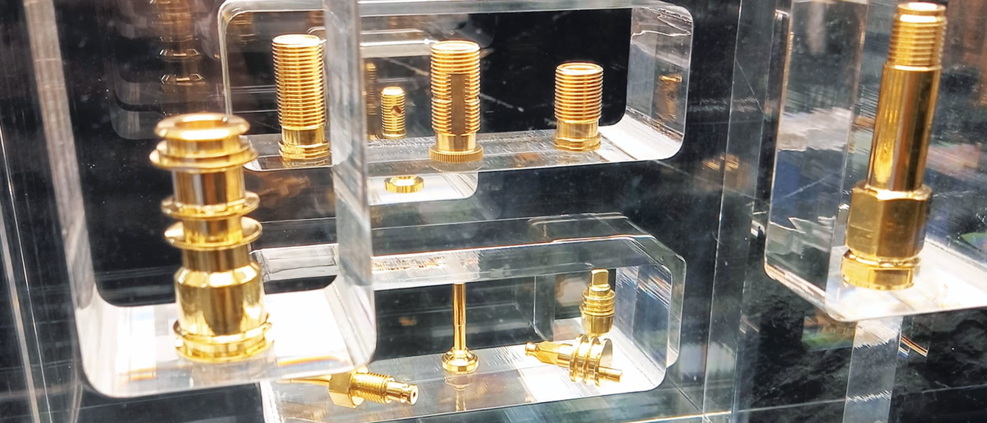 Dettaglio di componenti torniti in ottone esposti in teca trasparente presso lo stand Eredi Baitelli.