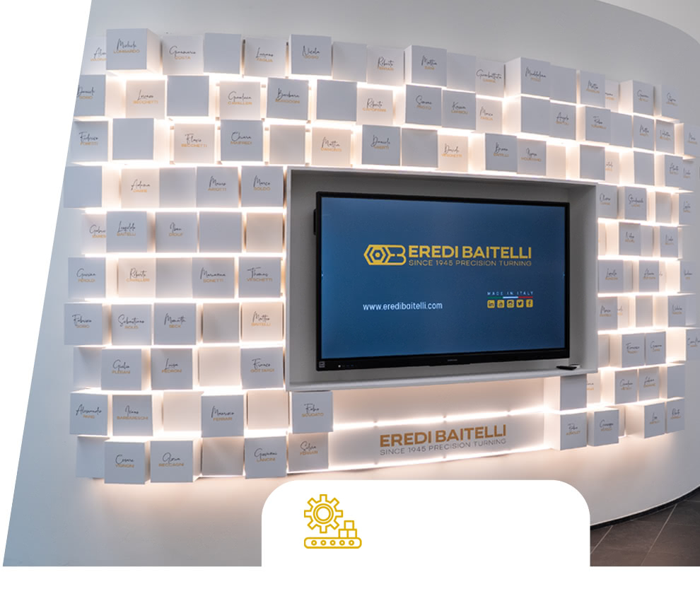 Wall of Fame Eredi Baitelli: parete illuminata con targhe nominative e schermo nell’area d’ingresso.