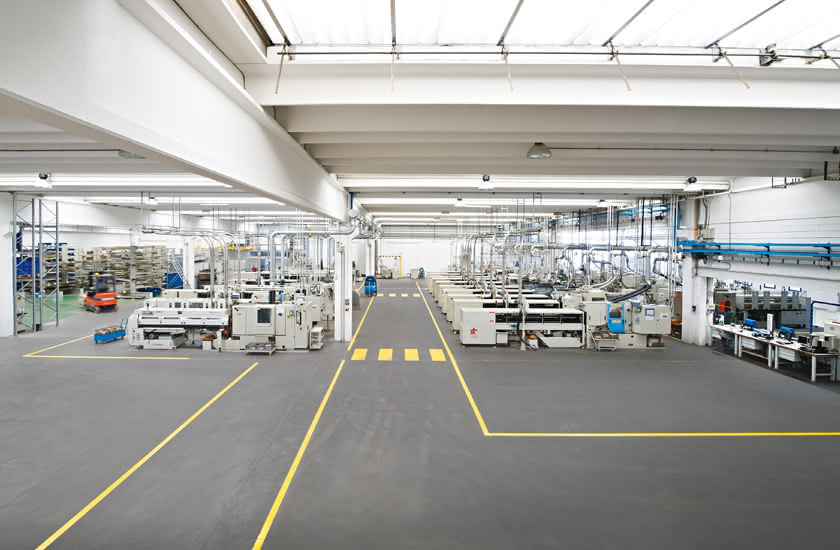 Interno dello stabilimento Eredi Baitelli inaugurato nel 1990 a Zocco di Erbusco, con torni automatici e corsie di sicurezza ben delineate.