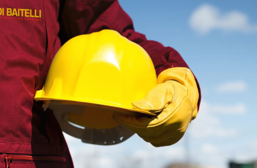 Operaio Eredi Baitelli con casco giallo e guanti da lavoro, simbolo dell’impegno per la sicurezza.